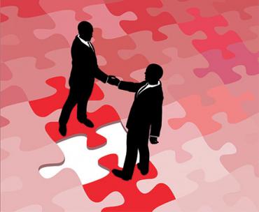 two people shaking hands on puzzle pieces