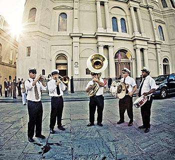 A brass band plays in front of St. Louis Cathedral